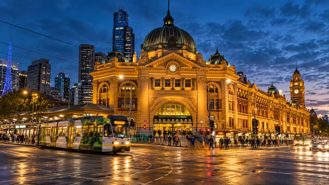 Flinders Street Station at dusk with a Melbourne tram passing
